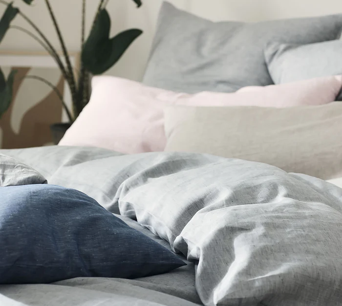 Ein Bett mit vielen Kissen und Halbleinen Bettwäsche