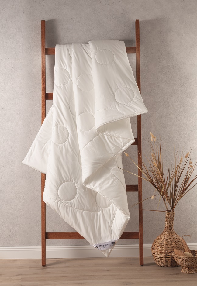 dormabell-bettdecke-klimafaser-wb3 Weisse Decke auf Holzleiter