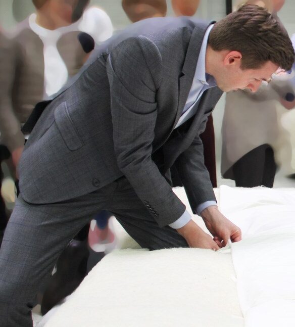 Betten-Check_Beratung_zuhause Mann prüft Stabilität und Qualität der Matratze