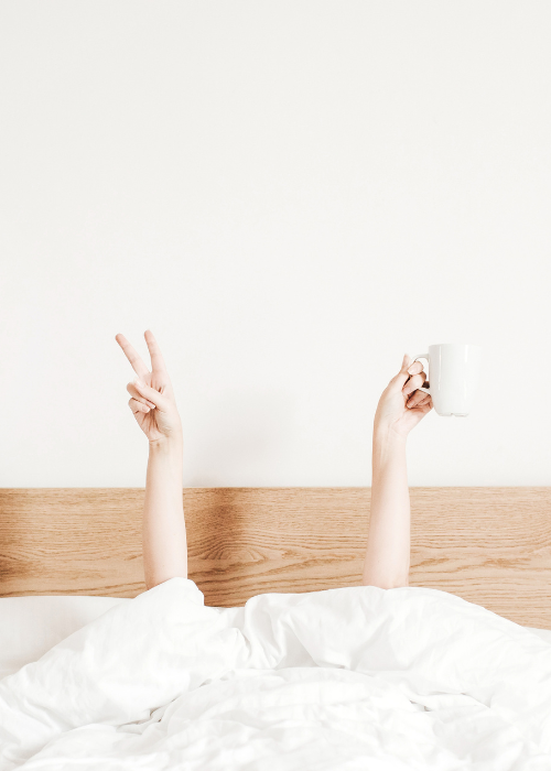 frau-unter-bettdecke Frau unter weisser Bettdecke